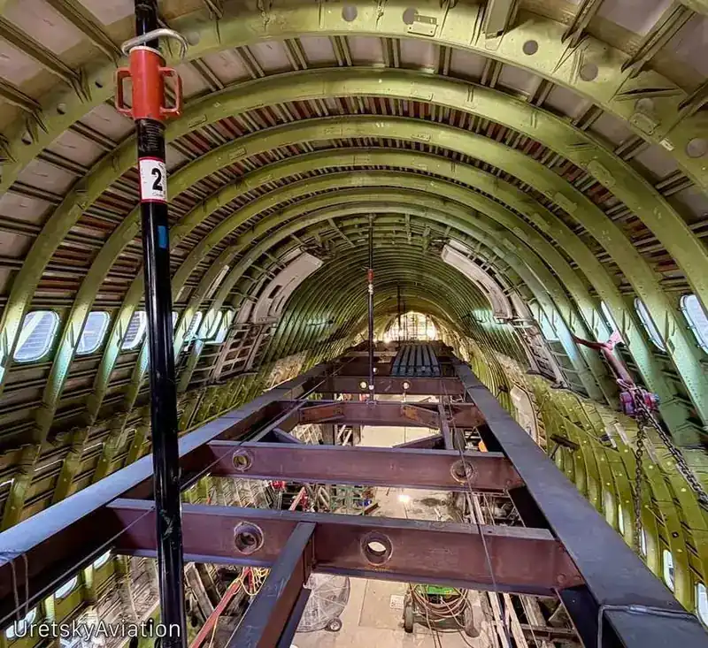 Boeing 747-400 bare metal fuselage interior showing structural frames, stringers and floor beams during heavy maintenance — N178UA