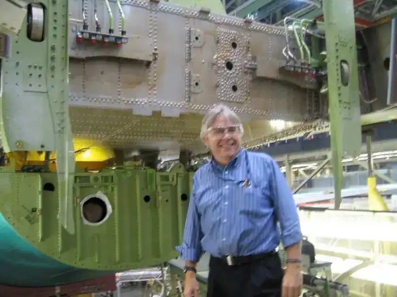Steve Clamp standing at Boeing 747 Bulkhead 2598 forward frame structure on the production line showing lightening holes, stiffeners and frame cutouts