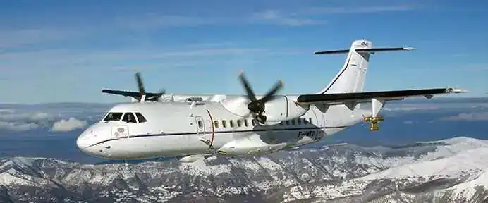 ATR 42 turboprop aircraft in flight over mountains
