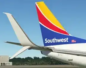 Southwest Airlines Boeing 737 winglet and tail on the runway — yellow/red/blue heart livery, showing the split-scimitar configuration with upper blade and lower ventral strake