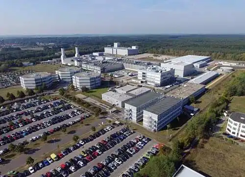 Aerial view of the Rolls-Royce Deutschland site at Dahlewitz, near Berlin — the company's centre of excellence for business aviation engines (BR710, BR715, BR725, Pearl 10X/15/700) and the UltraFan power-gearbox test facility. Office blocks at front, large assembly hangars and test stands behind.
