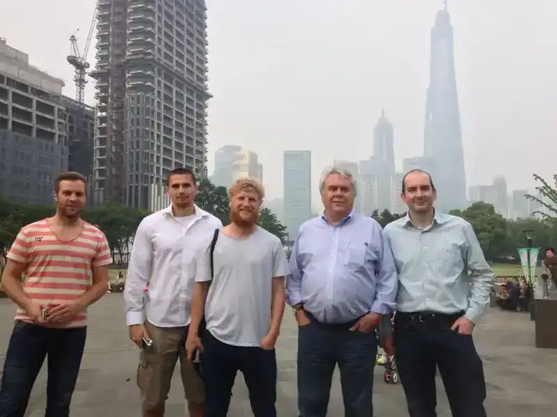 Steve Clamp with engineering team colleagues in Shanghai — Pudong skyline visible behind, Shanghai Tower under construction in the background