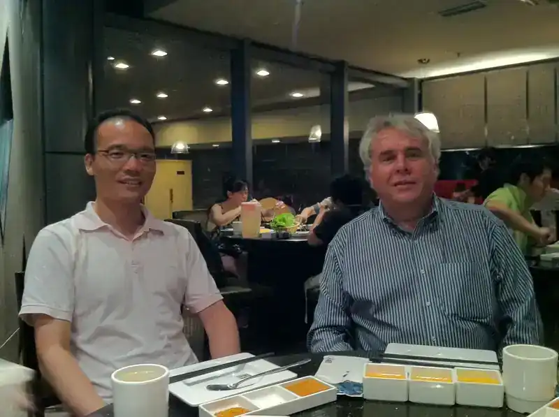 Steve Clamp and William seated at a restaurant table in Shanghai during the COMAC C919 development phase — informal dinner with engineering colleagues