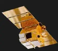 BeppoSAX spacecraft rendering — three-quarter view showing gold thermal blankets, segmented solar array wing, narrow-field instrument apertures on the upper deck and central spacecraft bus structure