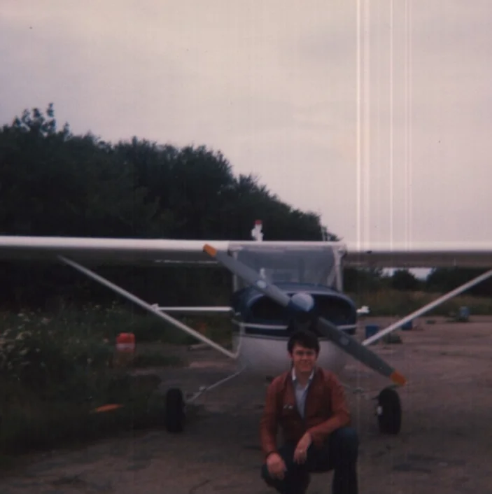 Steve crouching in front of his Cessna 150H at Cambridge UK